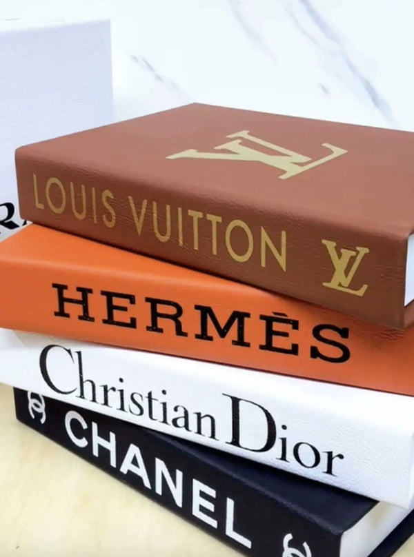 Quatre coffrets livres empilés, simili cuir fauve, orange, blanc et noir